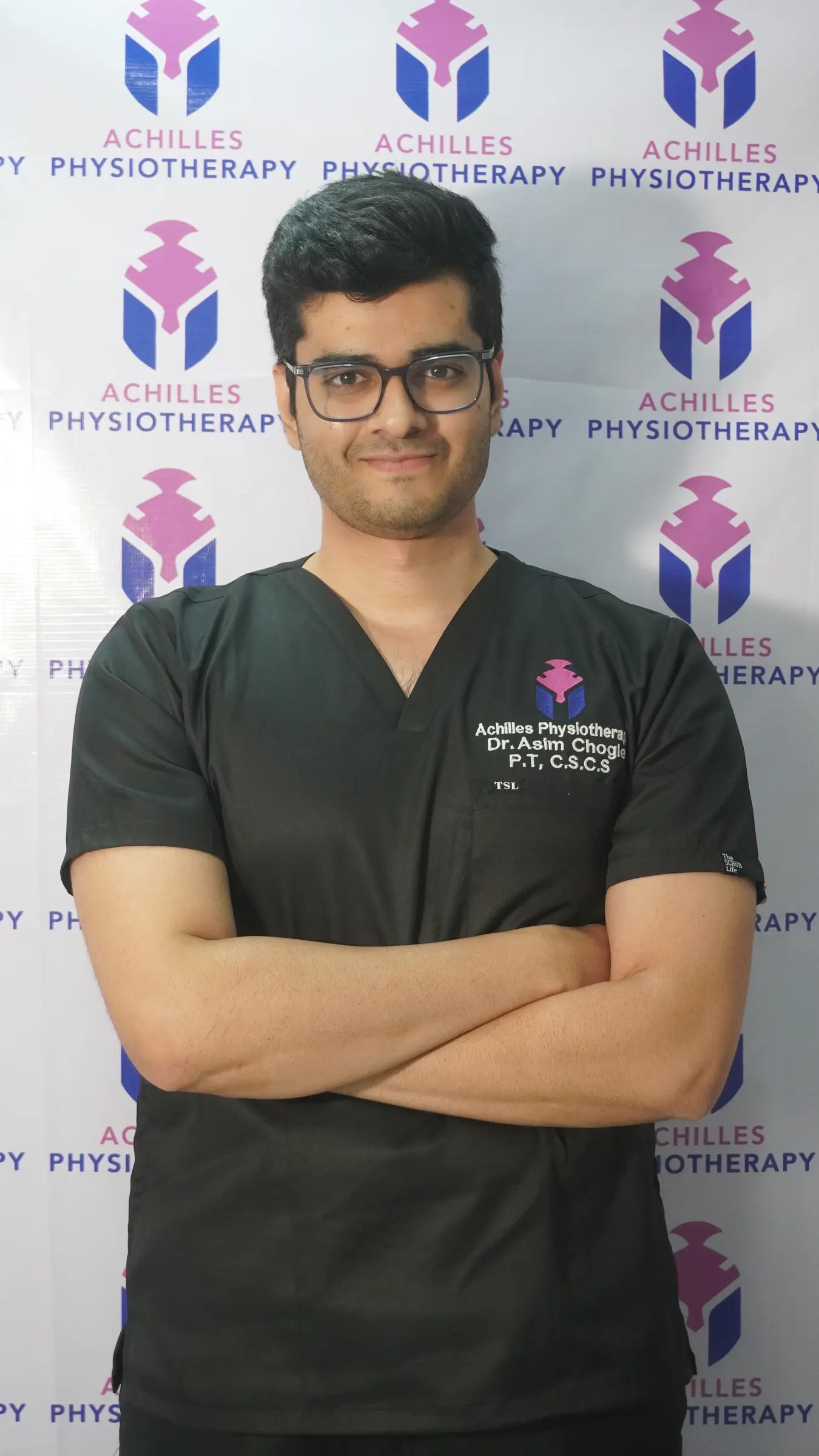 Dr Asim Chogle wearing Achilles Physiotherapy clinical scrubs